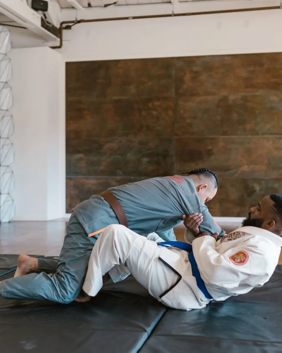 Two people grappling in gis on a mat